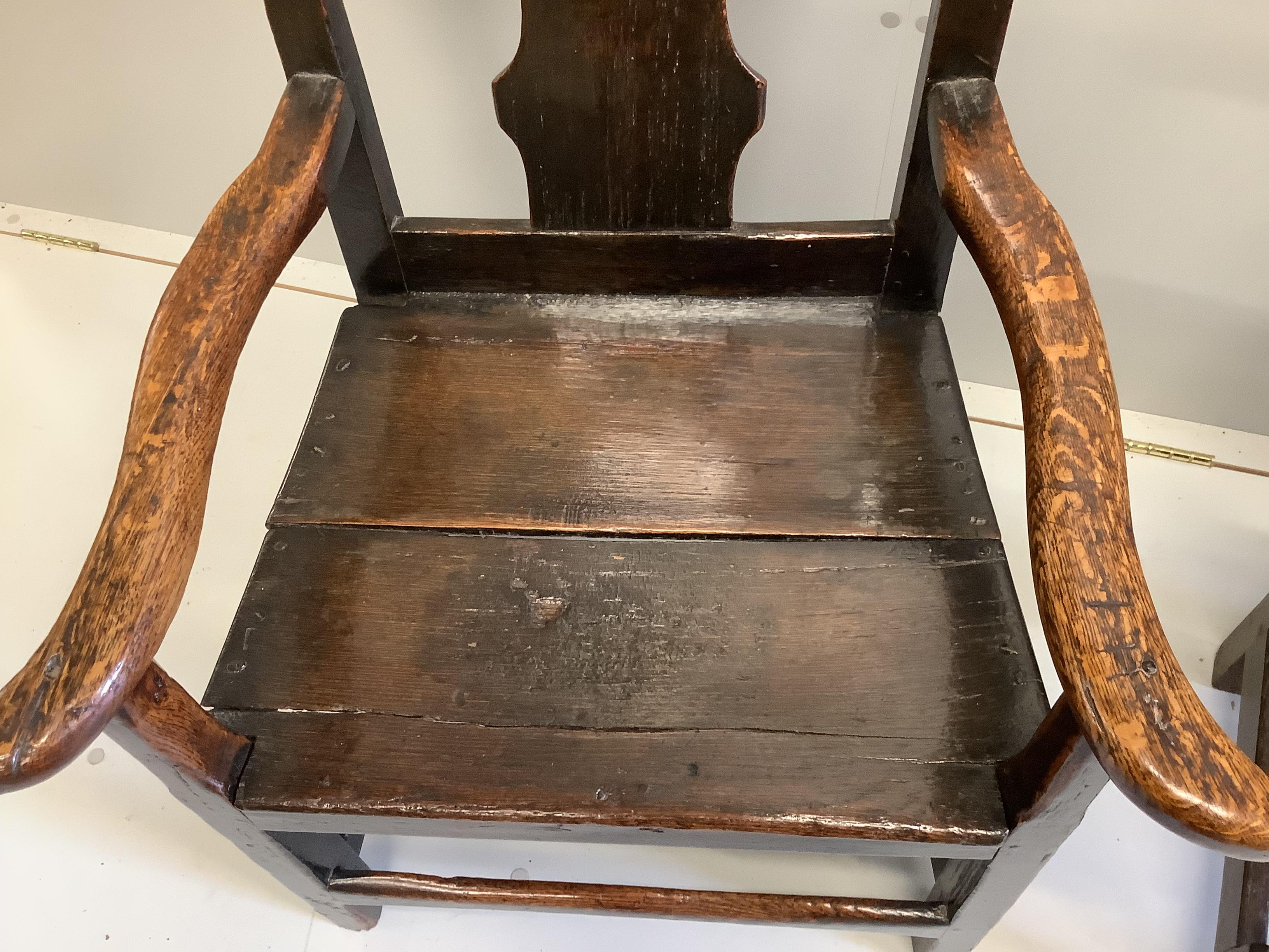 An early 18th century Provincial oak elbow chair, width 61cm, depth 50cm, height 100cm, together with a panelled high back dining chair